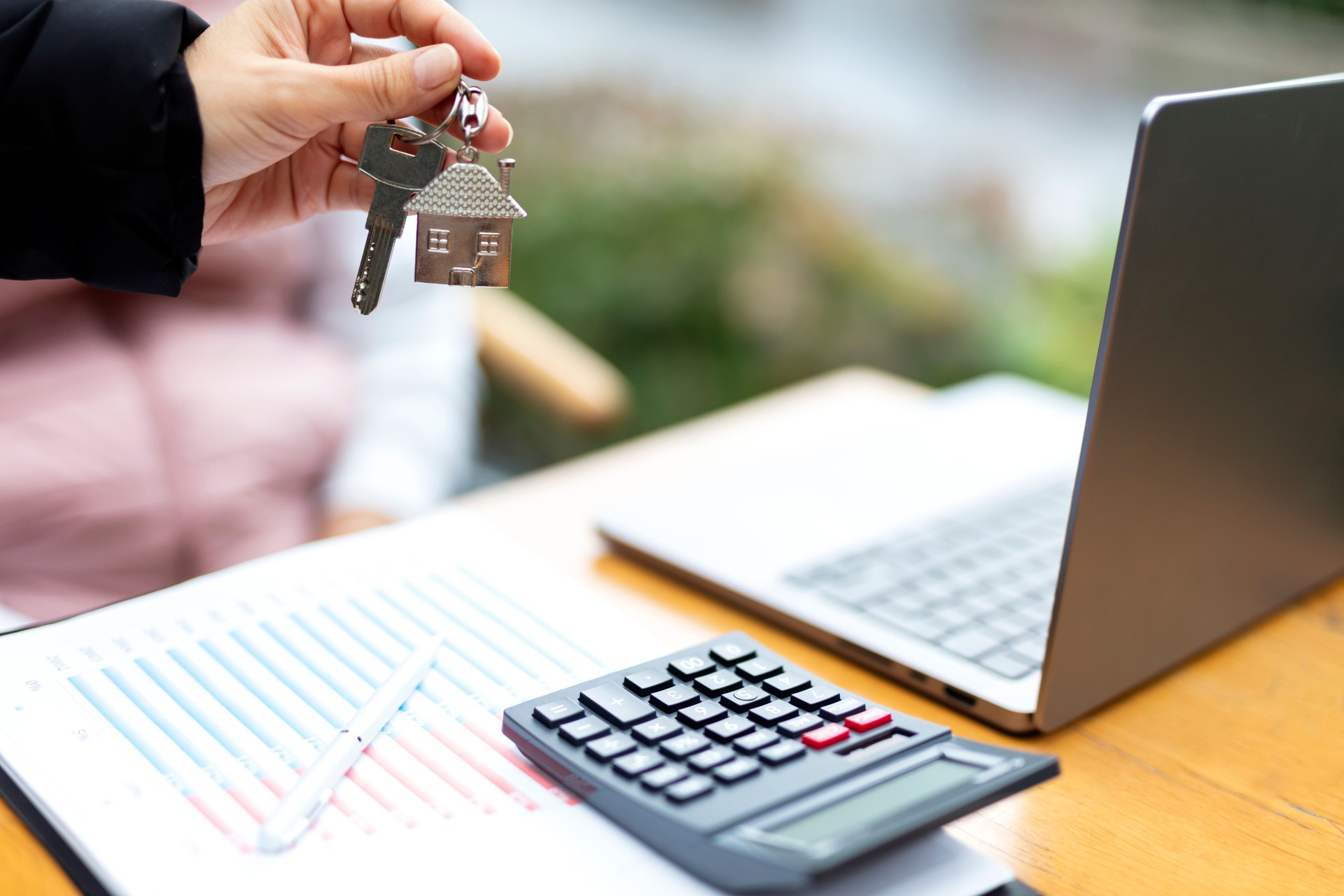 Real Estate Agent woman hands over the key of the house