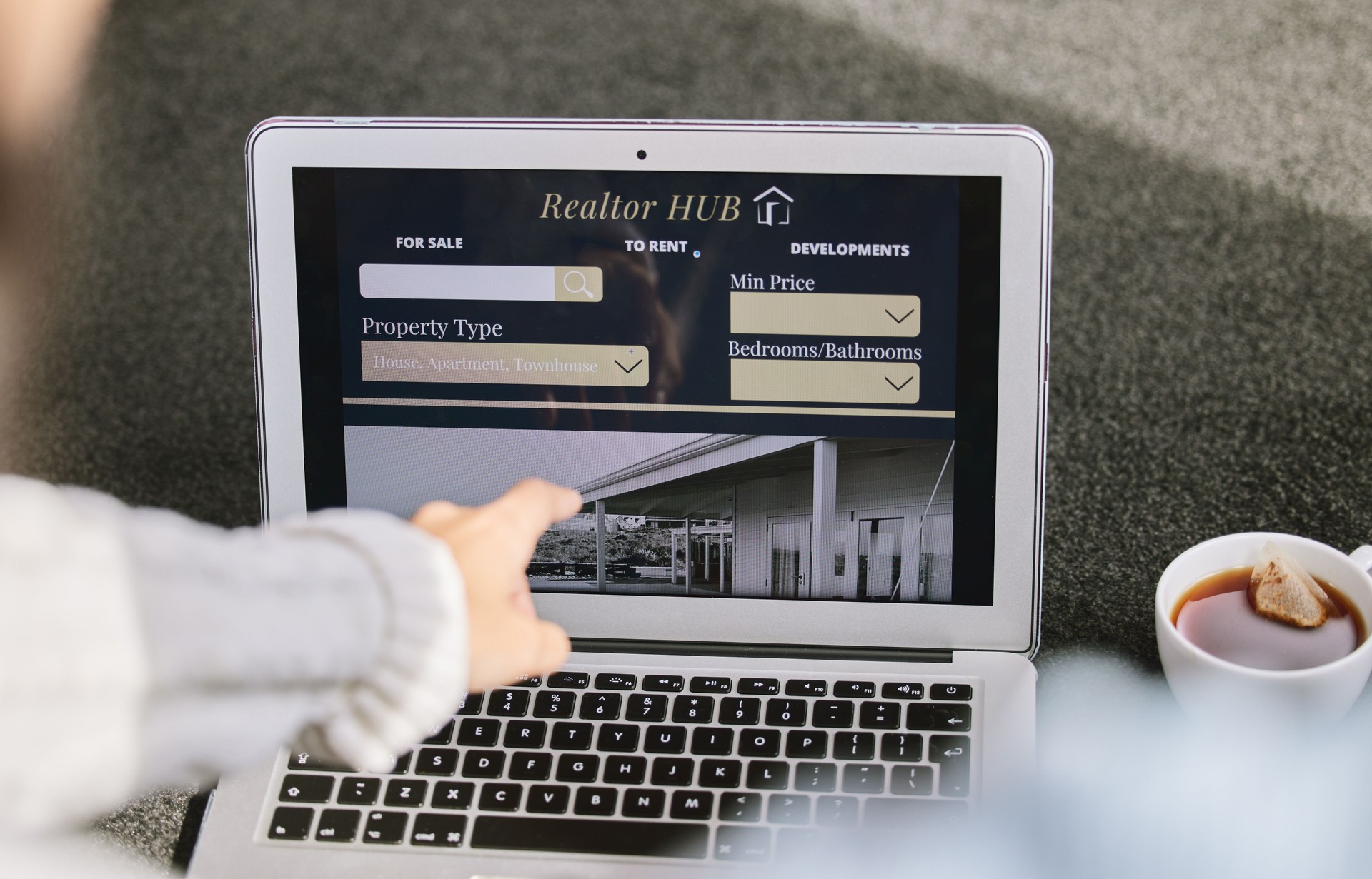 Cropped shot of an unrecognizable woman sitting and searching for new properties on her laptop